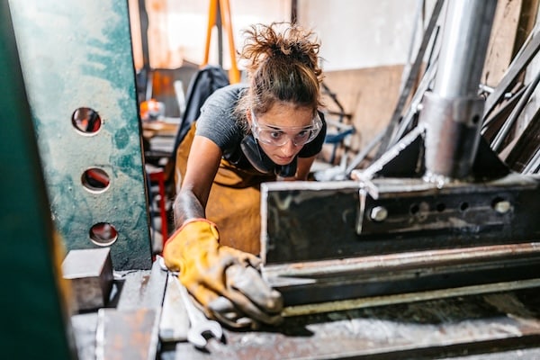 Woman examining her building materials as she learns how to build a metal building